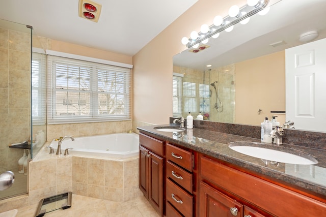 bathroom featuring a bath, a stall shower, visible vents, and a sink