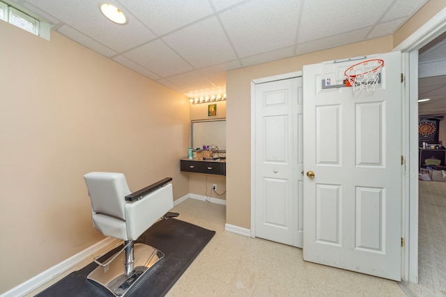 exercise room with baseboards, a drop ceiling, and tile patterned floors