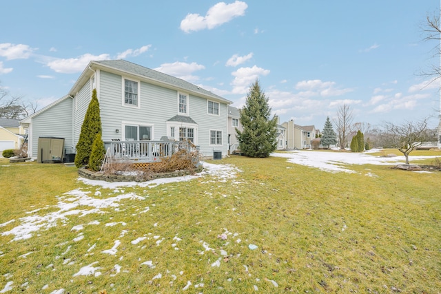 rear view of house featuring a lawn and a wooden deck