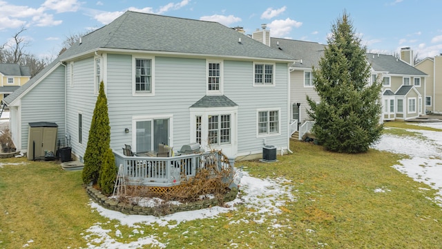 rear view of property featuring roof with shingles, a yard, a chimney, central air condition unit, and a wooden deck