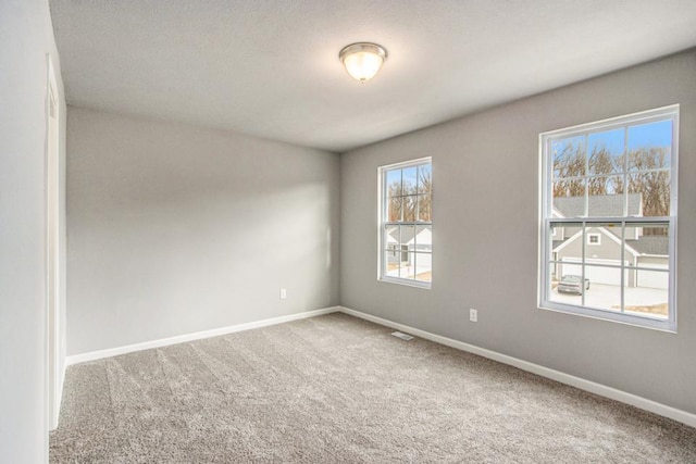 empty room featuring carpet floors and baseboards