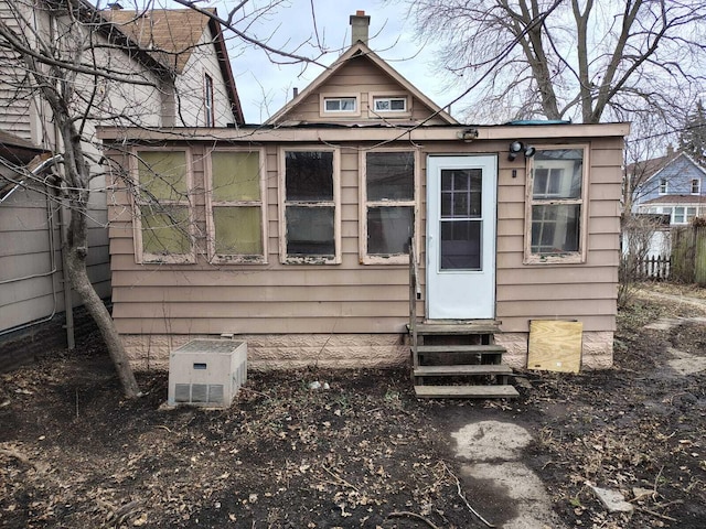 view of outdoor structure featuring entry steps and fence