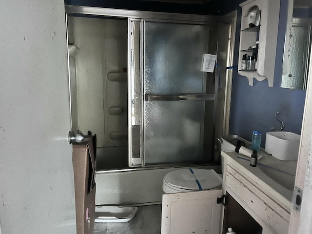 bathroom featuring enclosed tub / shower combo, vanity, and toilet