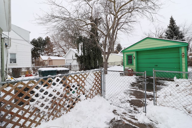 yard layered in snow featuring fence and an outdoor structure