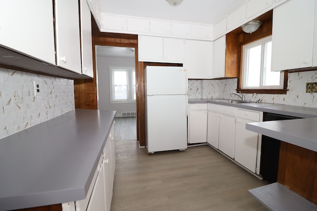 kitchen featuring white appliances, a wealth of natural light, white cabinets, and a sink