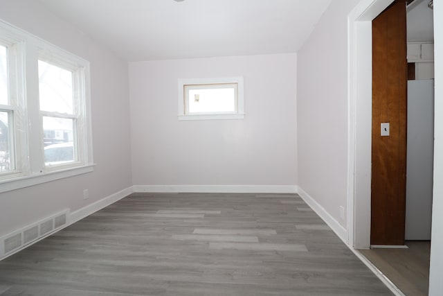 spare room featuring baseboards, visible vents, and light wood-style floors