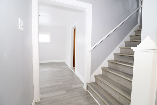 staircase featuring baseboards and wood finished floors