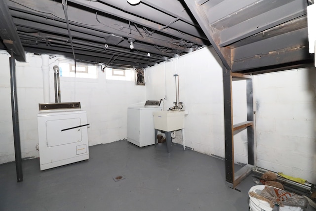 below grade area featuring a sink and washing machine and clothes dryer