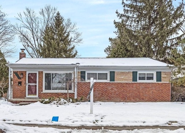 view of front of home with brick siding and a chimney