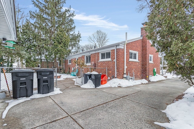 rear view of house featuring brick siding and a chimney