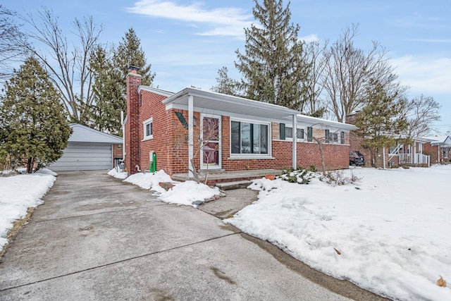 view of front of house featuring a garage, brick siding, a chimney, and an outdoor structure