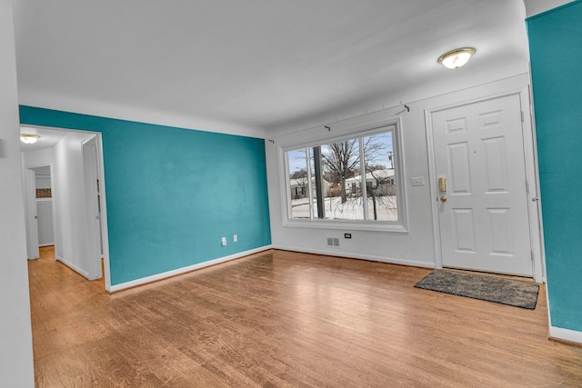 foyer entrance featuring light wood-style floors and baseboards