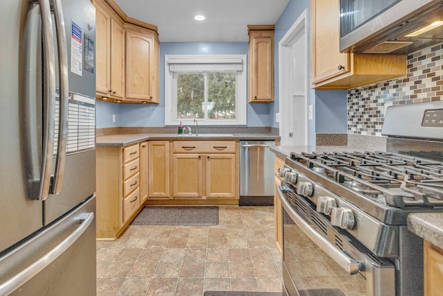 kitchen with tasteful backsplash, appliances with stainless steel finishes, light countertops, light brown cabinets, and a sink