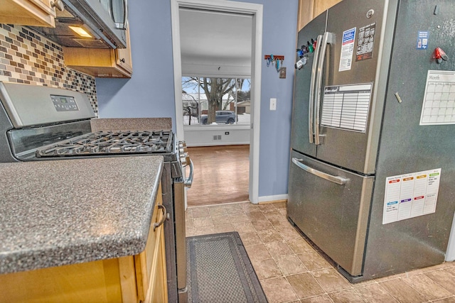 kitchen featuring stainless steel appliances, dark countertops, baseboards, and tasteful backsplash