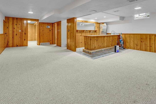 bar featuring carpet floors, recessed lighting, visible vents, wooden walls, and bar area