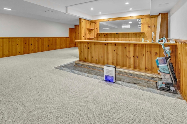 bar featuring carpet floors, a wainscoted wall, recessed lighting, wood walls, and a bar