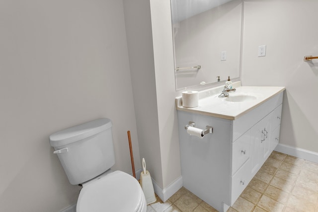 half bath featuring toilet, baseboards, and vanity