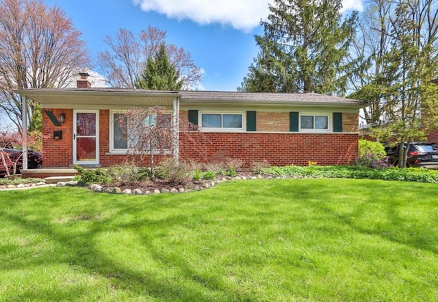 ranch-style house with brick siding, a chimney, and a front lawn