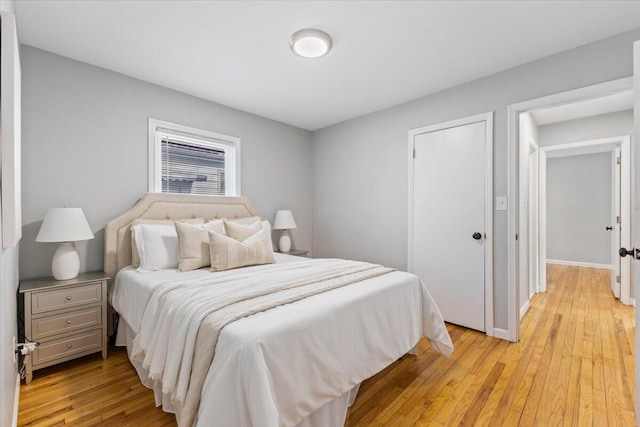 bedroom featuring light wood-style floors and baseboards