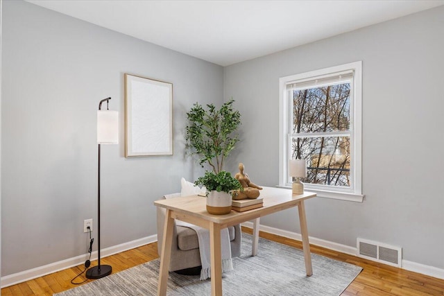 office area featuring light wood-type flooring, baseboards, and visible vents