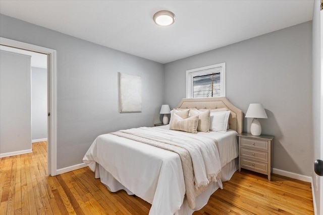 bedroom featuring light wood finished floors and baseboards