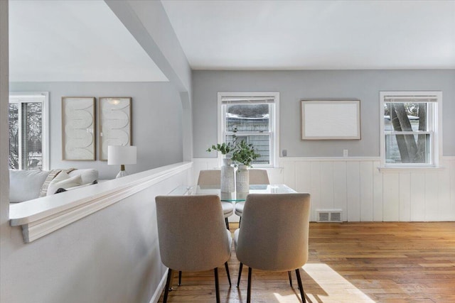 dining room with plenty of natural light, visible vents, wainscoting, and light wood-style flooring