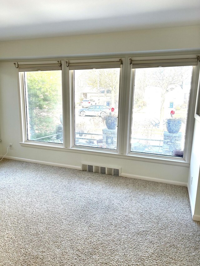 carpeted empty room with baseboards and visible vents