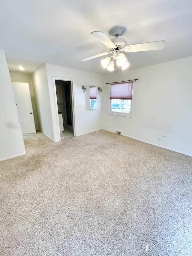 unfurnished room featuring ceiling fan, light carpet, visible vents, and baseboards