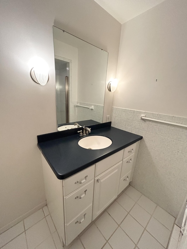 bathroom featuring wainscoting, tile patterned floors, vanity, and tile walls