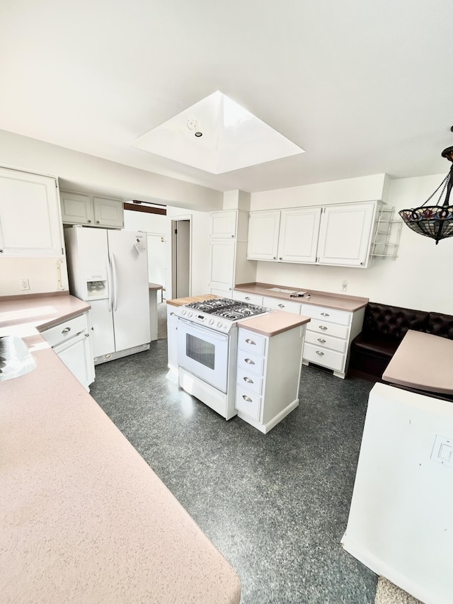 kitchen with a center island, white appliances, light countertops, and white cabinetry