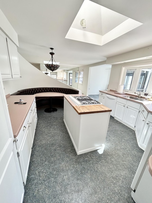 kitchen with dishwasher, wood counters, white cabinetry, and stainless steel gas stovetop