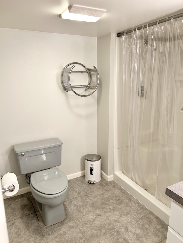 full bathroom with toilet, vanity, baseboards, a shower stall, and tile patterned floors