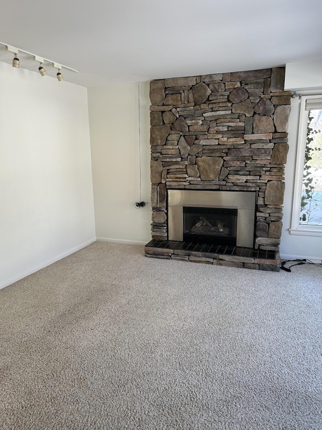 room details with a stone fireplace, carpet, and baseboards