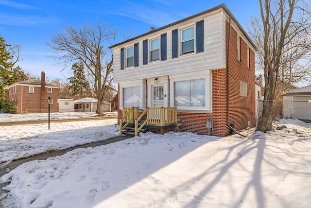 view of front of home featuring fence and brick siding