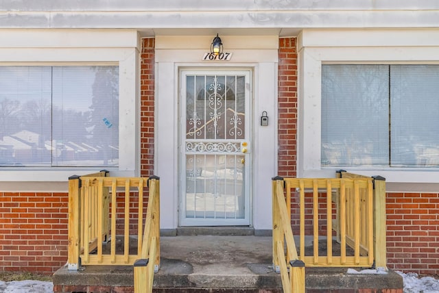 view of exterior entry featuring brick siding