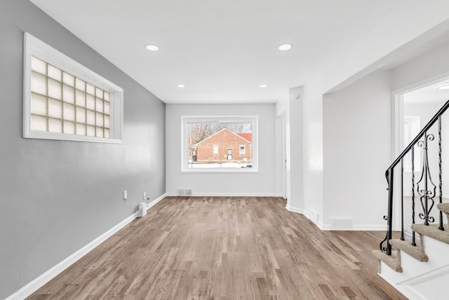 interior space with visible vents, stairs, light wood-style flooring, and baseboards