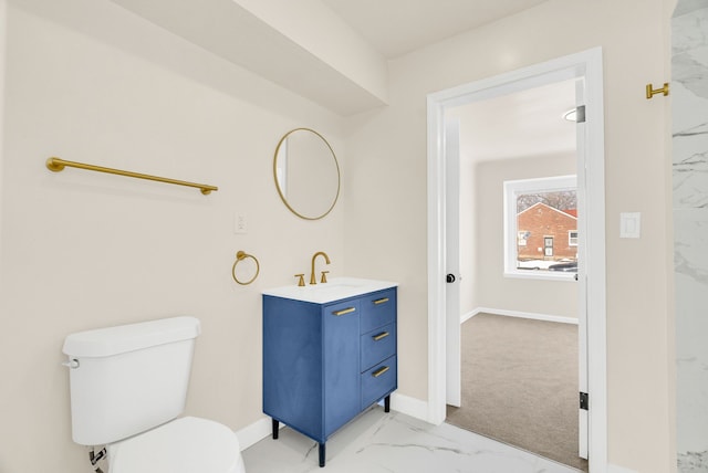 bathroom with toilet, marble finish floor, vanity, and baseboards