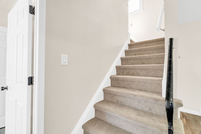 stairs with baseboards and wood finished floors