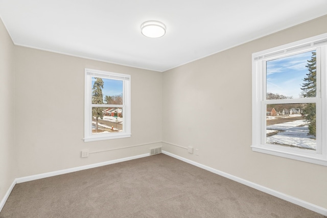 empty room featuring light carpet, baseboards, and visible vents