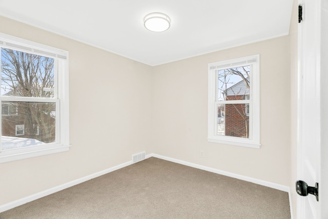 carpeted empty room with visible vents and baseboards