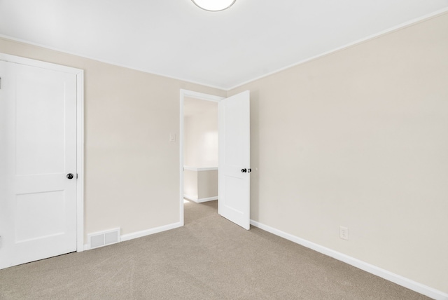 unfurnished bedroom featuring light colored carpet, visible vents, and baseboards