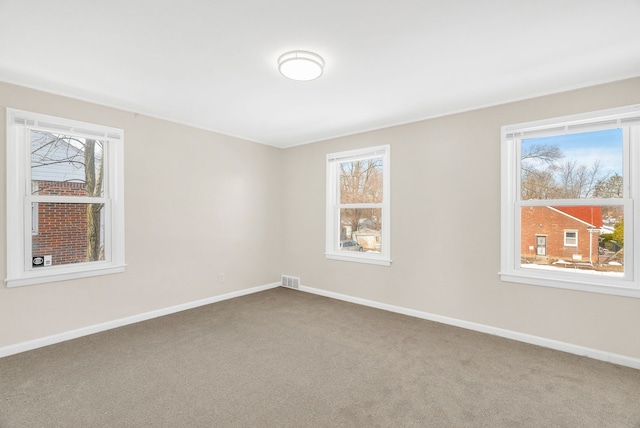 unfurnished room with a healthy amount of sunlight, baseboards, and carpet floors