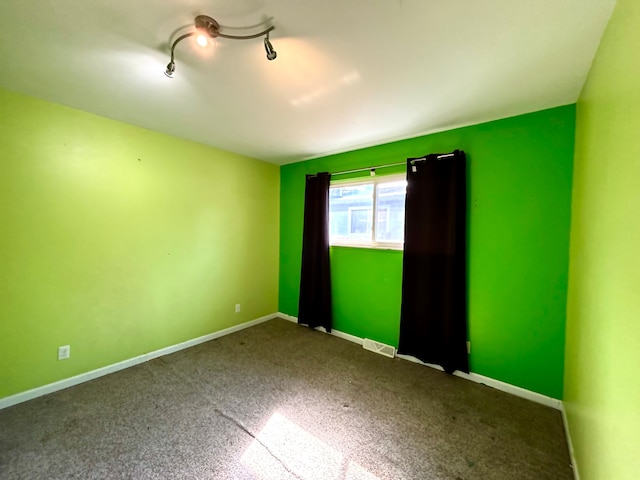 empty room featuring visible vents, baseboards, and carpet flooring