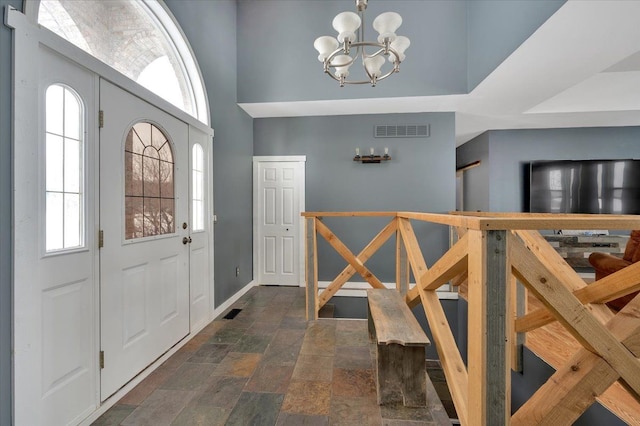 3912 Alex Ct, Oxford, MI 48371 - entrance foyer with a chandelier, plenty of natural light, dark stone finish floors, and baseboards