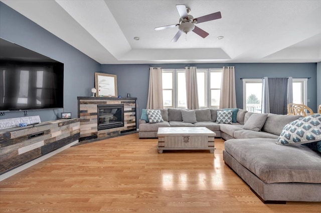 3912 Alex Ct, Oxford, MI 48371 - living room with a raised ceiling, wood finished floors, a ceiling fan, and a fireplace