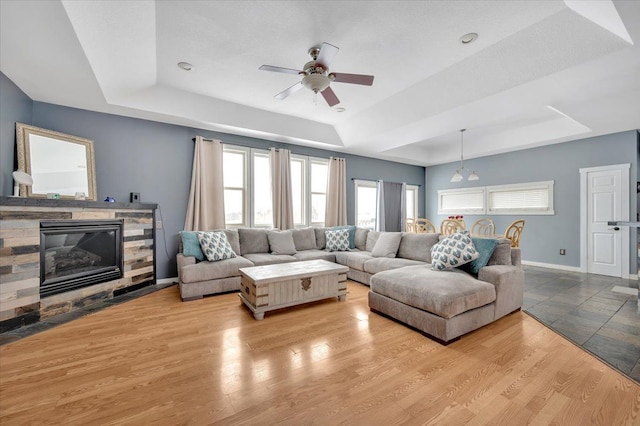 3912 Alex Ct, Oxford, MI 48371 - living area featuring a tray ceiling, ceiling fan, a fireplace, and baseboards
