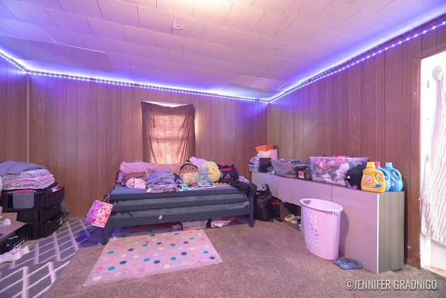 carpeted bedroom with wood walls