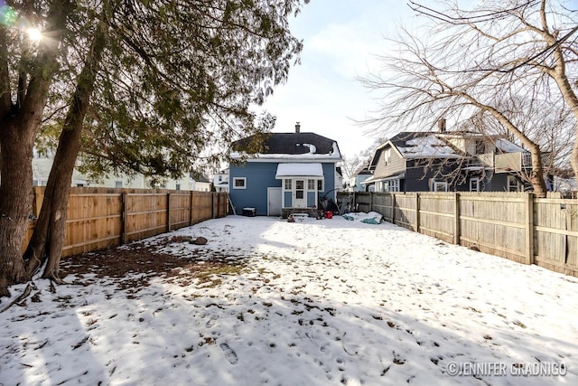 snow covered property with a fenced backyard