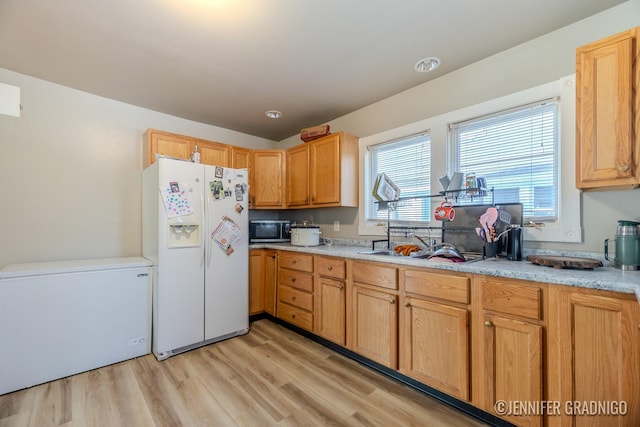 kitchen with white refrigerator with ice dispenser, stainless steel microwave, light wood-style flooring, and refrigerator