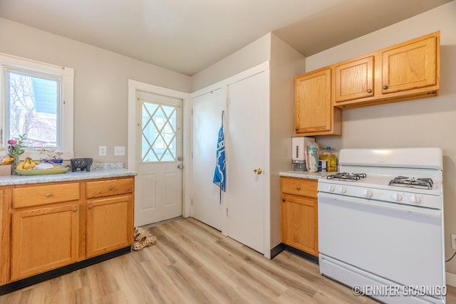 kitchen featuring light countertops, light wood-style floors, and white range with gas cooktop